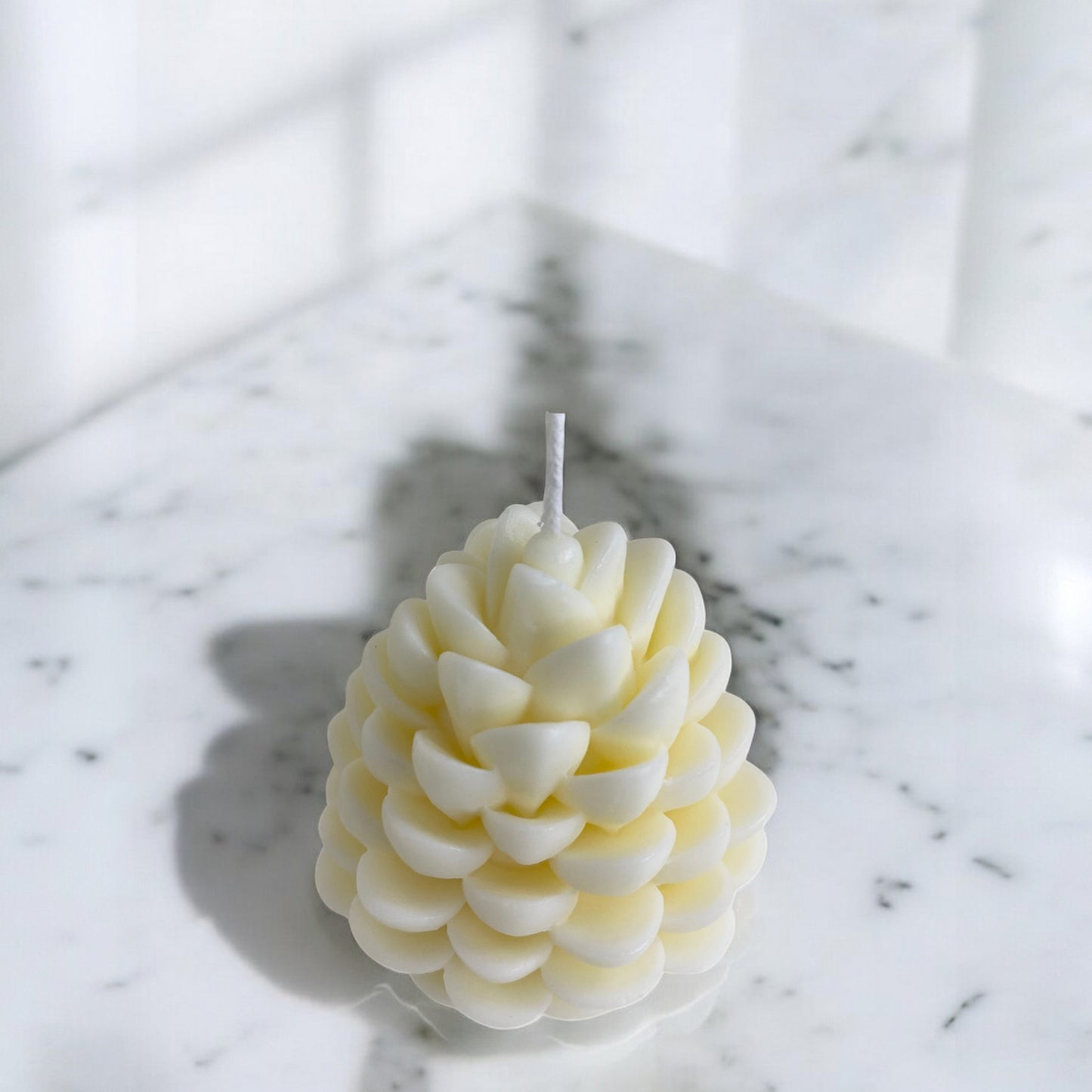 Bougie sculptée en forme de pomme de pin, cire végétale parfumée, idéale pour une ambiance cocooning et chaleureuse, couleur clair – HO'MAHA.