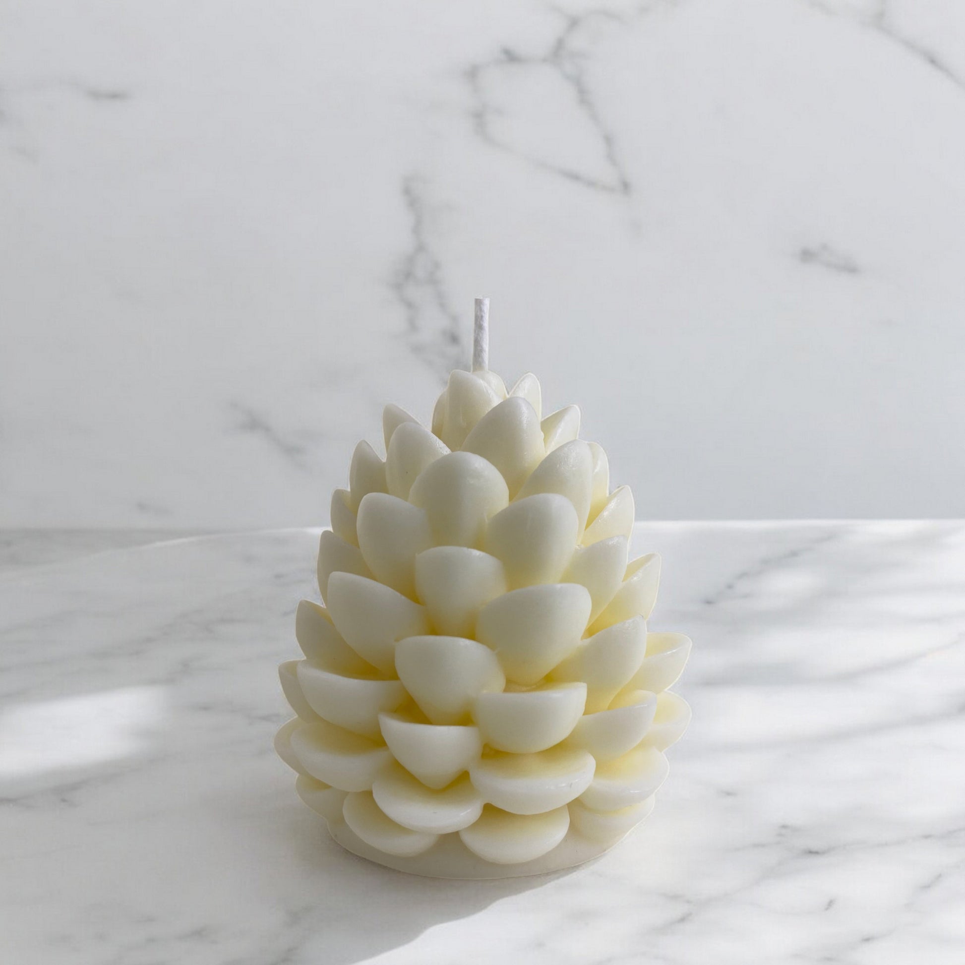 Bougie sculptée en forme de pomme de pin, cire végétale parfumée, idéale pour une ambiance cocooning et chaleureuse, couleur clair – HO'MAHA.